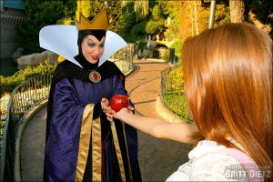 The Evil Queen offers an apple to a guest