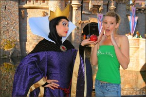 The Evil Queen offers an apple to a guest