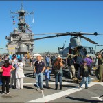 Civilians tour the flight deck of the USS Peleliu US Marine Amphibious Assault Carrier