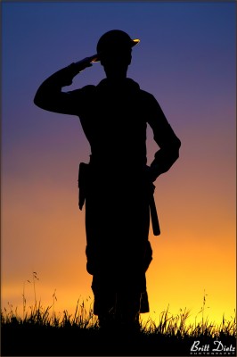 A WW2 Navy Shore Patrol reenactor salutes during dusk at the LA Air Raid 2011 event.